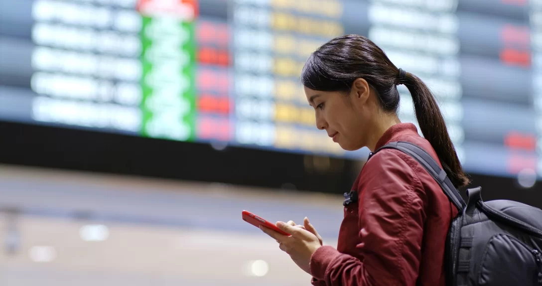 Passageira olhando o celular no aeroporto