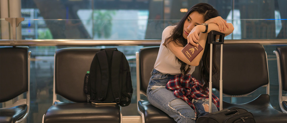 Passageira esperando sentada no aeroporto